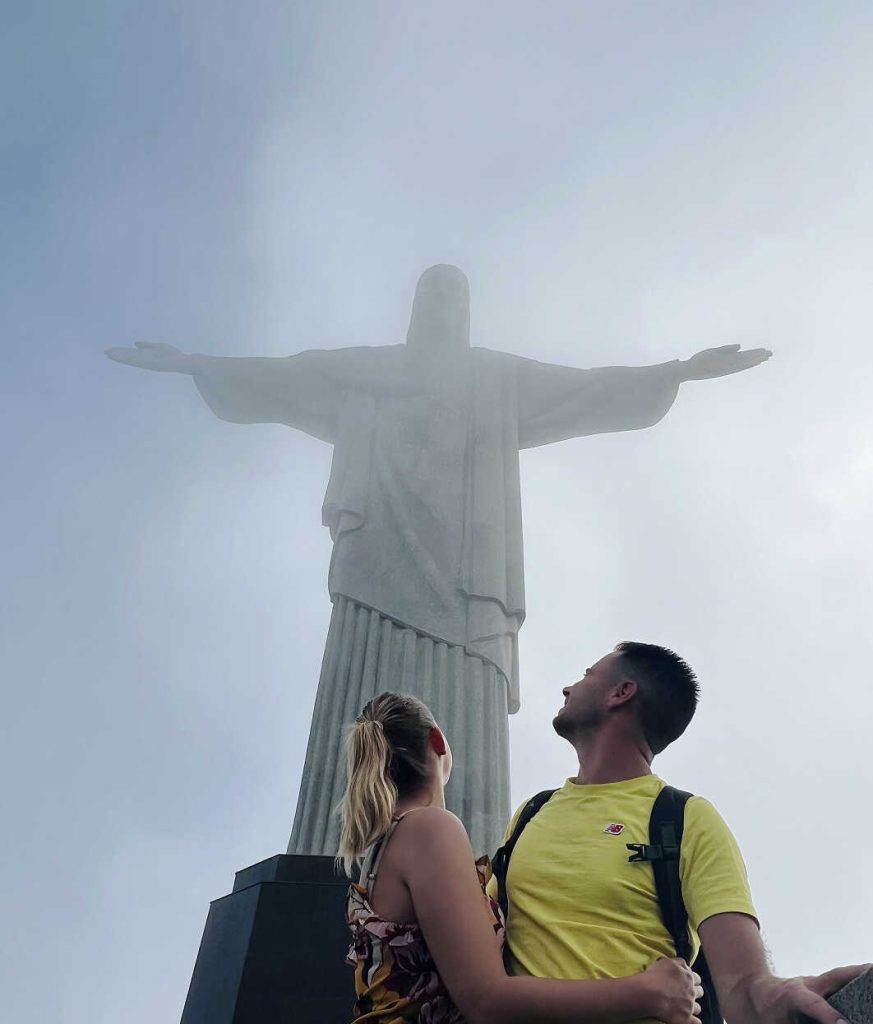 Couple admirant la statue du Christ Rédempteur dans la brume à Rio de Janeiro