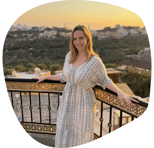Femme sur une terrasse avec vue sur le canyon de Jebel Shams à Oman au coucher du soleil